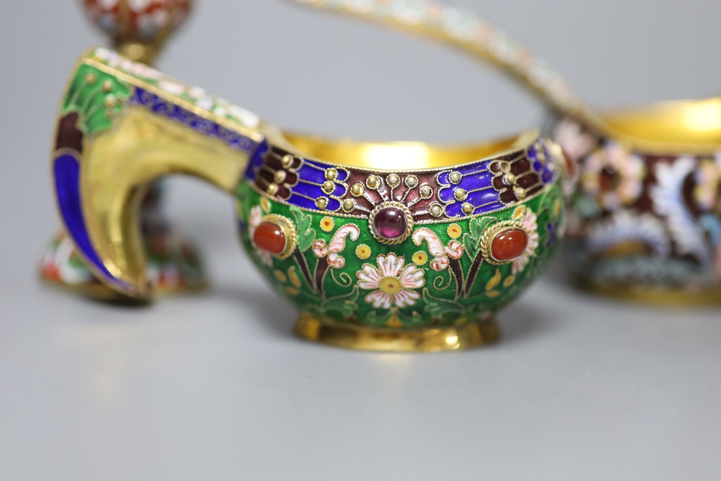 A group of Russian style white metal and enamel items including kovshs, egg pendants and small cups.